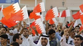 Anti-government protesters shout slogans while holding Bahraini flags during a protest outside Bahrain's leading opposition party Al Wefaq's headquarters in Manama, May 9, 2012.