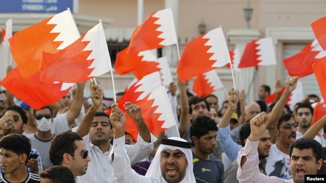 Anti-government protesters shout slogans while holding Bahraini flags during a protest outside Bahrain's leading opposition party Al Wefaq's headquarters in Manama, May 9, 2012.