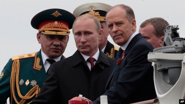 Tổng thống Nga Vladimir Putin cùng với Bộ trưởng Quốc phòng Sergei Shoigu (trái) và Giám đốc Cơ quan An ninh Alexander Bortnikov (phải) trên 1 chiếc thuyền ở Sevastopol, Crimea, 9/5/2014.