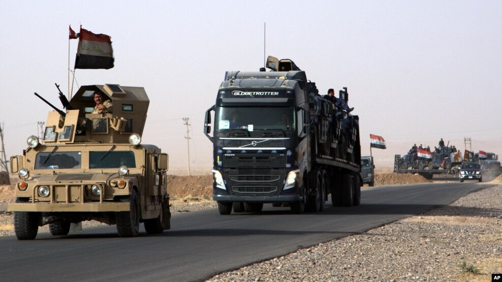 A convoy of Iraqi military vehicles heads toward Qayyarah base in northern Iraq, ahead of an expected offensive to retake Mosul from Islamic State militants, Oct. 15, 2016.