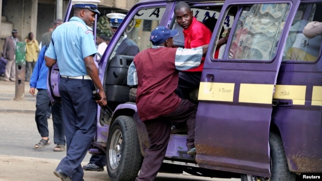 A September 2006 file photo shows a Kenyan policeman boarding a minibus  after the vehicle was stopped for a traffic offence in the capital Nairobi.