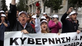 Οι εργαζόμενοι από τα συνθήματα του συστήματος υγείας κραυγή Ελλάδα ως το banner διαβάζει'''' κυβέρνηση κατά τη διάρκεια μιας διαμαρτυρίας ενάντια στις περικοπές για την υγεία κυβέρνηση στην Αθήνα, 17η Απριλίου 2013. 
