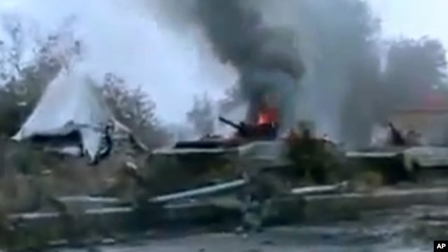 Tank militer Suriah terbakar api di luar kota Deir Ezzor (29/1). (AP/Ugarit News)