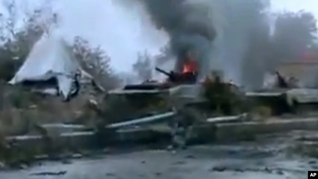 A Syrian military tank is shown as having caught fire outside Deir Ezzor in this January 29, 2013, file photo.