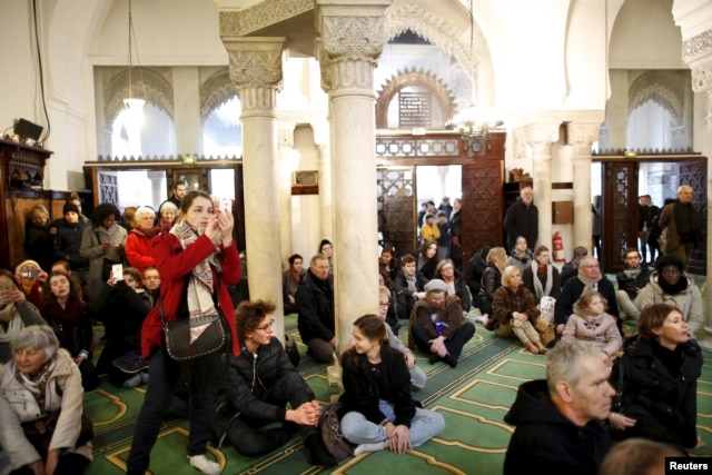 Visitors watch members of the Muslim community praying in the Paris Grand Mosque during an open day weekend for mosques in France, Jan. 10, 2016.