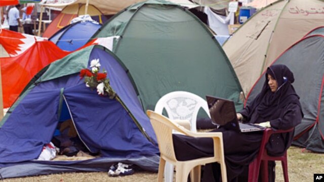 An anti-government Bahraini protester listens to religious programming on the internet outside her tent at Pearl Square in Manama (February 2011 file photo)