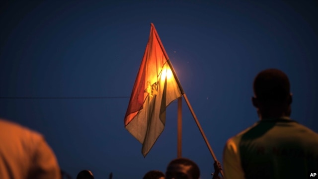 A protestor holds a Burkina Faso national flag during a protest against a recent coup in Ouagadougou, Burkina Faso, Sept. 21, 2015..