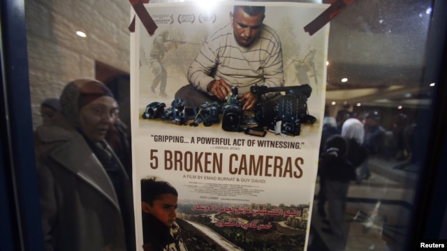 Poster film dokumenter nominasi Oscar "5 Broken Cameras" dipasang di bioskop di Ramallah, Tepi Barat (28/1). (Reuters/Mohamad Torokman)