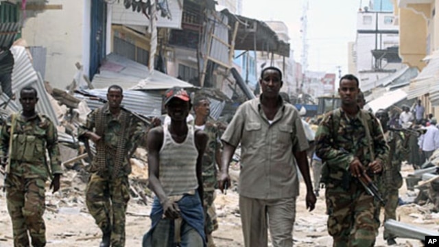 Somali government soldiers patrol a section of Bakara market following the demolition of illegal structures erected next to access roads in Mogadishu, April 30, 2012.