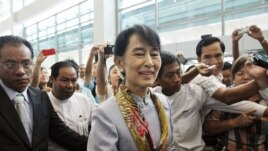 Myanmar's pro-democracy leader Aung San Suu Kyi makes her way through the Yangon International Airport as she leaves for her trip to Europe June 13, 2012.