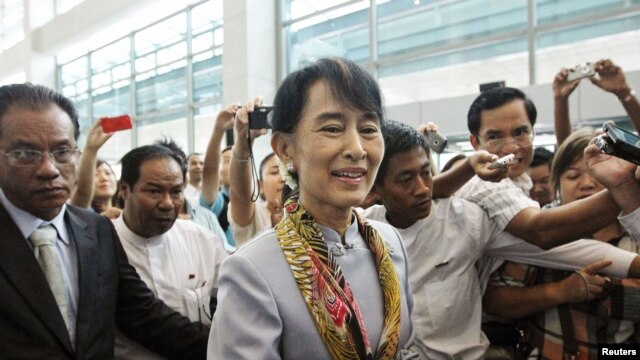 Myanmar's pro-democracy leader Aung San Suu Kyi makes her way through the Yangon International Airport as she leaves for her trip to Europe June 13, 2012.