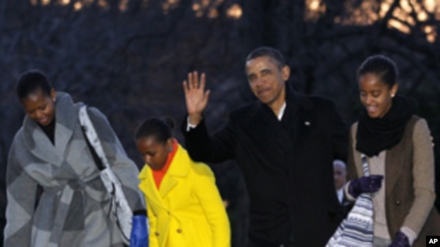 President Barack Obama, first lady Michelle Obama and their daughters Sasha and Malia arrive on the South Lawn of the White House, Tuesday, Jan. 3, 2012, in Washington.