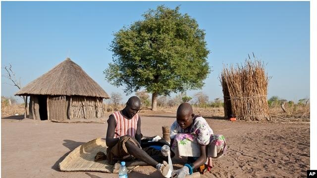 Feb. 8, 2010. Senwei Village, Terekeka Region, South Sudan. Guinea worm Eradication Program Village Volunteer Puru tends to her husband, Garbino's Guinea worm leg wound, at their home.