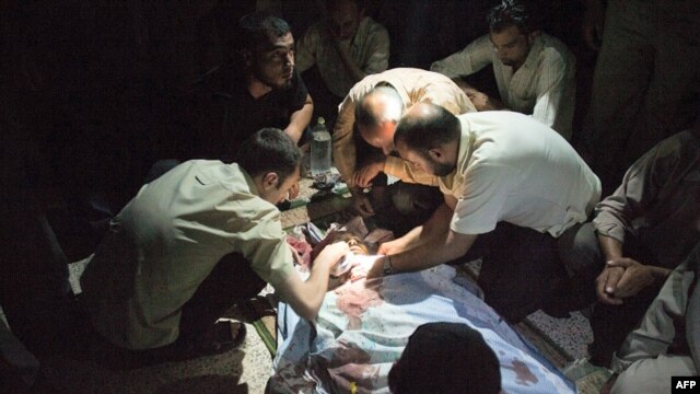 Syrians mourn over Mohammed Hafez, 30, who was killed by a gunshot to the head in Izaz, July 13, 2012