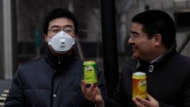 Doanh nhân triệu phú Trần Quang Tiêu (phải) đưa một lon không khí sạch cho một người đeo mặt nạ tại trung tâm thủ đô Bắc Kinh.