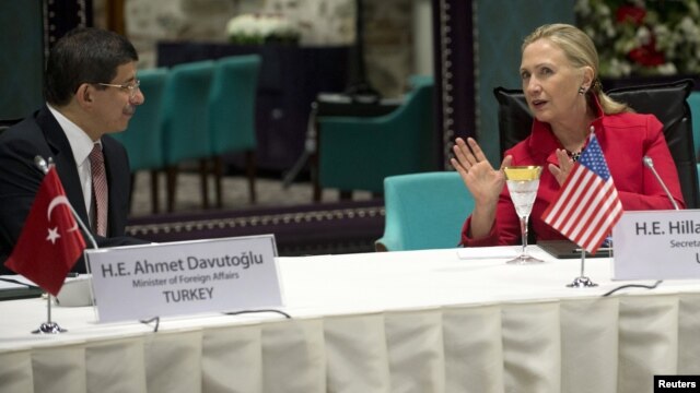 Foreign Affairs Minister Ahmet Davutoglu of Turkey listens to U.S. Secretary of State Hillary Clinton as they attend a "Friends of Syria" meeting in Istanbul June 6, 2012.