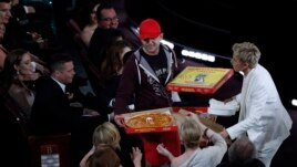 Show host Ellen DeGeneres gives out pizza at the Academy Awards.