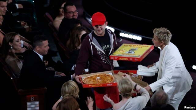 Show host Ellen DeGeneres gives out pizza at the Academy Awards.