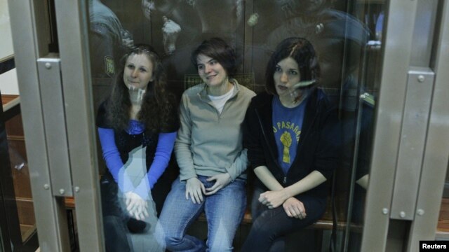 Members of the female punk band 'Pussy Riot' sit in a glass-walled cage before a court hearing in Moscow, October 1, 2012. 