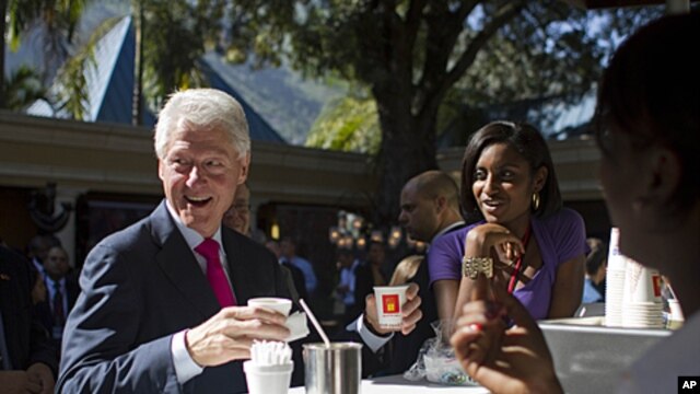 Former U.S. President and U.N. special envoy to Haiti, Bill Clinton, left, holds a coffee before the opening ceremony of an investor conference at the Karibe hotel in Port-au-Prince, Haiti, November 29, 2011.
