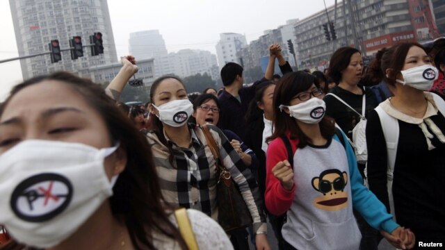 People shout slogans as they march during a protest against plans to expand a petrochemical plant in Ningbo, Zhejiang province, October 28, 2012. 
