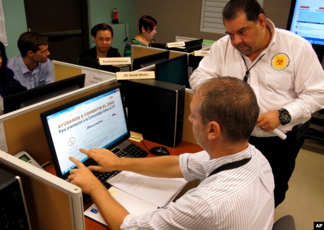 FILE - Puerto Rico Health Department workers monitor social media for Zika related issues at the department's headquarters in San Juan, Puerto Rico.