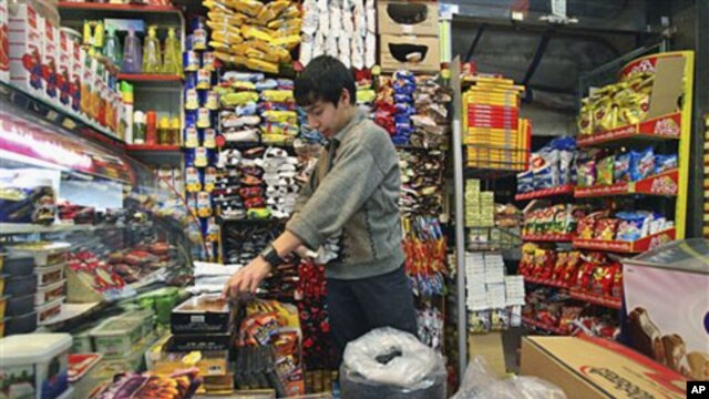 Iranian worker Jafar Rahimi works at his shop in central Tehran, Iran, after Iran's President Mahmoud Ahmadinejad announced the start of a plan to slash energy and food subsidies, part of government efforts to boost the nation's ailing economy, Dec. 18, 2