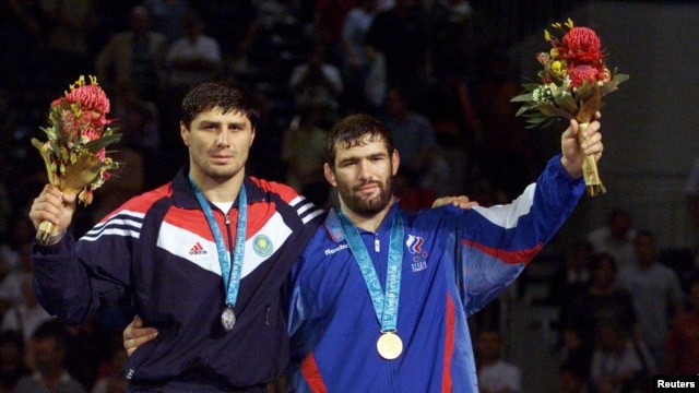 FILE - Gold medalist Sagid Mourtasaliyev (R) poses with silver medallist Islam Bairamukov at the Olympic Games in Sydney, September 30, 2000. 
