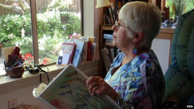 Joan Davies Rapp of Tacoma, Washington, counts and records bird sightings outside her living room window as part of Project FeederWatch. (VOA/T. Banse)