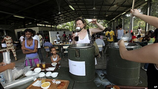 Evacuees who fled fighting in Ivory Coast prepare to eat breakfast in the French camp of Port Bouet, which houses about 3000 French and other foreign citizens, in Abidjan, April 8, 2011