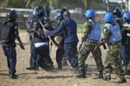 Liberian riot policeman drag away a commander who fired live rounds while storming the compound of the opposition Congress for Democratic Change headquarters in the capital Monrovia, Liberia, November 7, 2011.