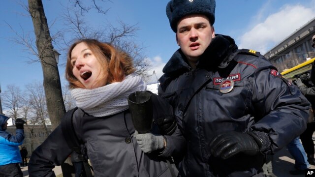 Полицейский арестовывает активистку антифашистского движения. Санкт-Петербург. Россия. 22 марта 2015 г.