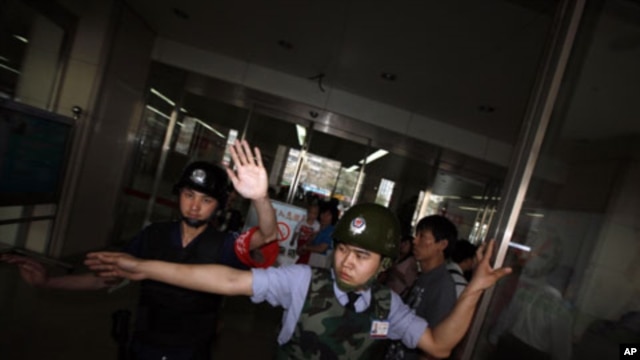 Chinese security guards block journalists at the entrance of a hospital where blind activist lawyer Chen Guangcheng is recuperating in Beijing,  May 4, 2012.