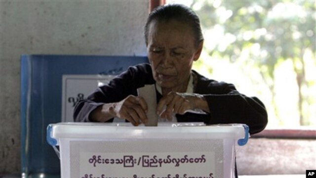 A woman casts her ballot at a local polling station on Sunday, 7 Nov. 2010, in Bago, about 90 km northeast of  Rangoon, Burma.