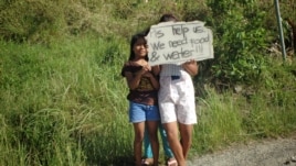 Children wait on roadsides hoping to get handouts from passing motorists, Cebu, Philippines, Nov. 15, 2013. (Steve Herman/VOA)