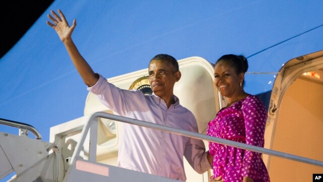 Tổng thống Barack Obama và phu nhân Michelle Obama vẫy chào khi họ bước lên chuyên cơ Air Force One tại căn cứ Joint Base Pearl Harbor-Hickam, kết thúc kỳ nghỉ của gia đình, hôm 2/1.