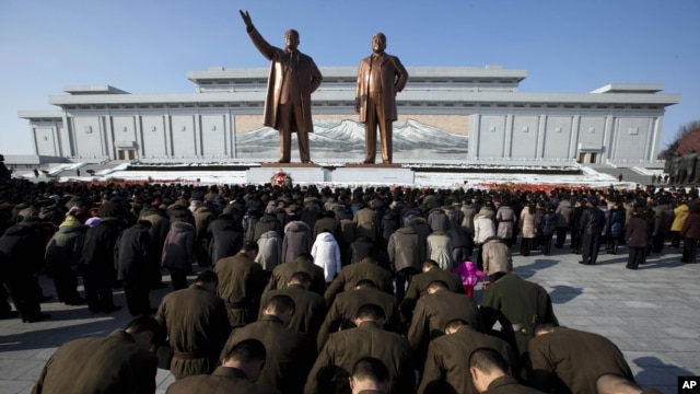 North Korean soldiers bow before the statues of late leaders Kim Il Sung, left, and Kim Jong Il, right, at Mansu Hill in Pyongyang, North Korea, December 17, 2012.