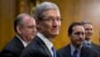 Apple CEO Tim Cook, center, is surrounded by his team during a break from testifying on Capitol Hill in Washington, May 21, 2013. 