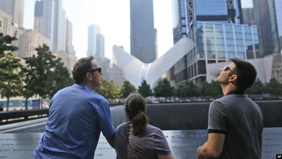 Visitors to the National September 11 Memorial take in the view from the north pool, Saturday, Sept. 10, 2016, in New York. Sunday marks the 15th anniversary of the attacks on the World Trade Center. (AP Photo/Mary Altaffer)
