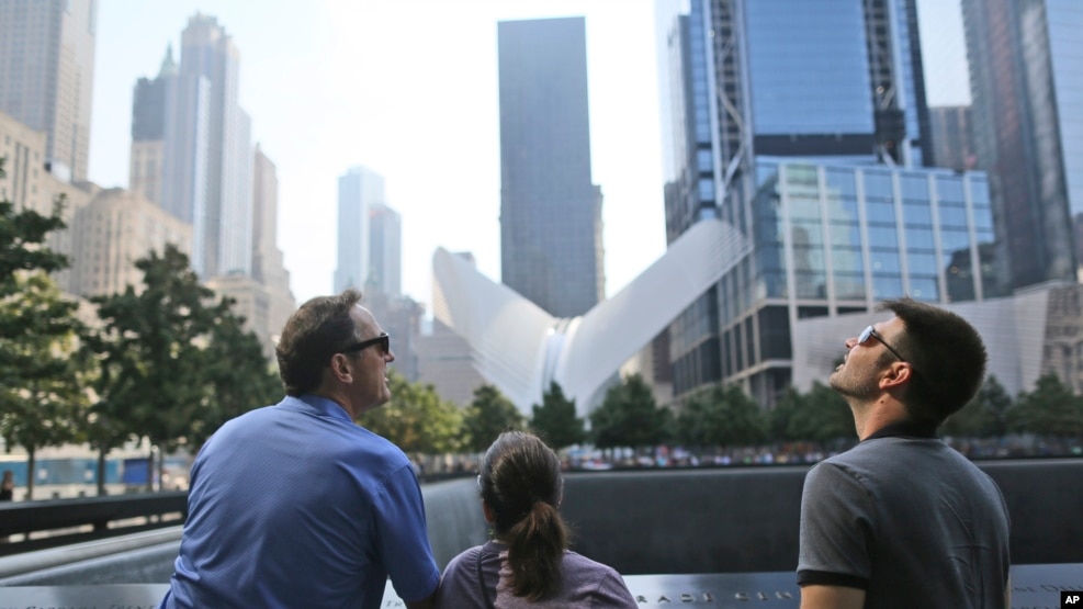 Visitors to the National September 11 Memorial take in the view from the north pool, Saturday, Sept. 10, 2016, in New York. Sunday marks the 15th anniversary of the attacks on the World Trade Center. (AP Photo/Mary Altaffer)