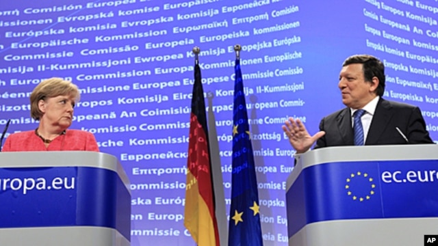 German Chancellor Angela Merkel, left, looks at European Commission President Jose-Manuel Barroso as he speaks during a news conference at the European Commission headquarters in Brussels, Oct. 5, 2011.