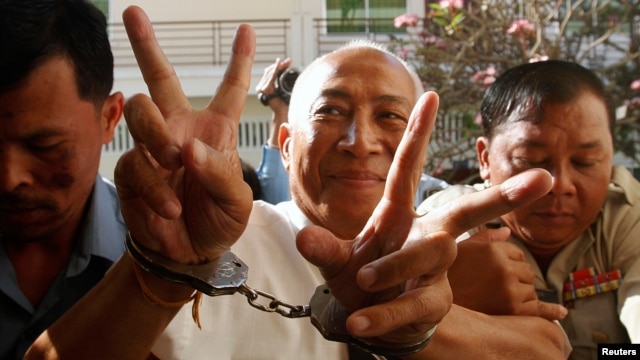 Mam Sonando (C), owner of a local independent radio station and land rights campaigner, gestures as he arrives at the Appeal Court in Phnom Penh, March 5, 2013. 