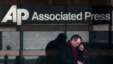 A man looks down at his smartphone as he walks past the offices of the Associated Press in Manhattan, New York,  May 13, 2013.