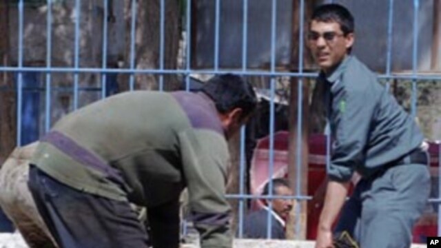 Afghan policemen carry a casualty from the site of a suicide attack in Faryab province, north of Afghanistan, April 4, 2012. 