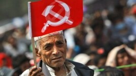 A supporter of Nepal Communist Party Maoist waves a flag during a mass rally in Katmandu, Nepal, June, 15, 2012. 