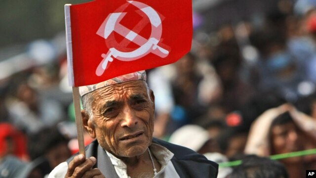 A supporter of Nepal Communist Party Maoist waves a flag during a mass rally in Katmandu, Nepal, June, 15, 2012. 