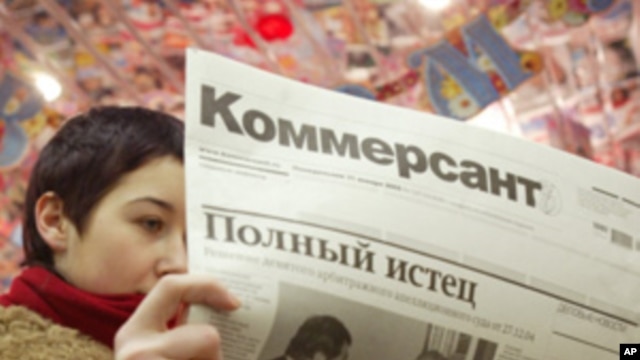 A Muscovite reads the latest issue of Kommersant with most of its pages blank at a metro station in central Moscow.  (File Photo)