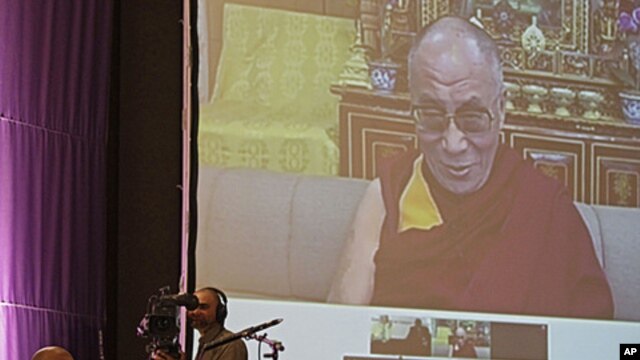 South African Archbishop Desmond Tutu, sitting at left,  speaks during a live video link with Tibetan spiritual leader the Dalai Lama, on screen, near the city of  Cape Town, South Africa, October 8, 2011.