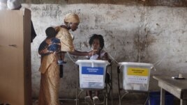 Une femme votant à Freetown le 17 novembre 2012
