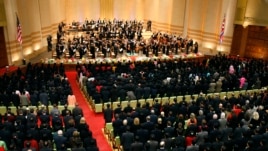 Quốc kỳ của Mỹ và Bắc Triều Tiên treo trên sân khấu, và khán giả đứng lên khi dàn nhạc New York Philharmonic trình tấu quốc ca Hoa Kỳ trước khi bắt đầu buổi hòa nhạc